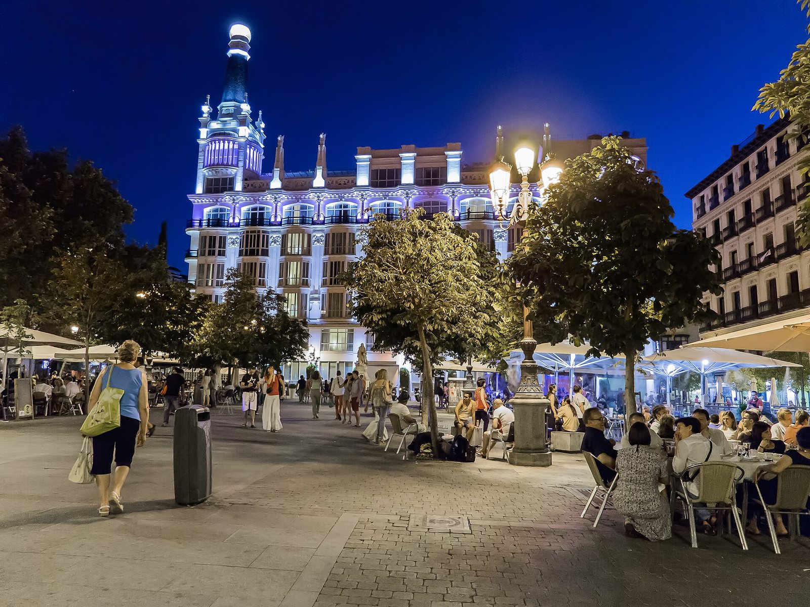 Plaza de Santa Ana al anochecer con terrazas y el hotel iluminado